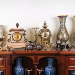 Antique wooden sideboard displaying heirloom clocks, brass candlesticks, porcelain vases and silver pieces representing furniture storage needs in Johannesburg