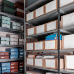 Metal archive shelves stacked with labelled coloured and cardboard document boxes in a secure physical document storage facility in Johannesburg